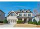 Charming two-story home featuring a welcoming front porch, attached two-car garage, and manicured landscaping at 4425 Atwood Dr, Cumming, GA 30040