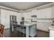 Open kitchen and breakfast bar with stainless steel appliances and modern white cabinetry at 4425 Atwood Dr, Cumming, GA 30040