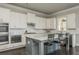 Open kitchen featuring a gray kitchen island, white cabinets, and modern stainless appliances at 4425 Atwood Dr, Cumming, GA 30040