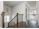 Staircase landing with dark wood floors and iron railing, featuring decorative light fixtures at 4425 Atwood Dr, Cumming, GA 30040