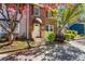 Brick townhouse featuring an awning covered entryway, complemented by vibrant foliage and charming landscaping at 8827 Applegate Ln, Atlanta, GA 30350
