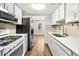 Kitchen features updated stainless appliances, white cabinets, and access to an adjacent living space at 8827 Applegate Ln, Atlanta, GA 30350