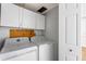 Functional laundry room with a side-by-side washer and dryer and upper cabinets at 8827 Applegate Ln, Atlanta, GA 30350