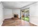 Spacious living room features a brick fireplace, wood floors, and sliding glass doors to a patio at 8827 Applegate Ln, Atlanta, GA 30350