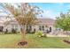 Well-maintained backyard features a lush lawn, brick house, patio furniture, and a charming garden at 1152 Simonton Glen Way, Lawrenceville, GA 30045