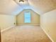 An empty bedroom with sloped ceilings, carpet flooring, and a single window offers a blank canvas at 1152 Simonton Glen Way, Lawrenceville, GA 30045