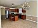 Open-concept kitchen and dining space featuring warm cabinetry and stylish modern lighting at 1152 Simonton Glen Way, Lawrenceville, GA 30045