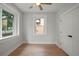 Bright bedroom with wood-look floors, ceiling fan, and white trim around the windows and door at 1441 Ezra Church Nw Dr, Atlanta, GA 30314