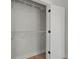 An organized closet with white shelves and a partial view of the white door with black hinges at 1441 Ezra Church Nw Dr, Atlanta, GA 30314