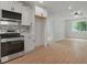 Bright, white kitchen with stainless steel appliances, luxury vinyl plank flooring, and new cabinetry at 1441 Ezra Church Nw Dr, Atlanta, GA 30314