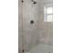Tiled shower with bronze shower head and fixture inside a glass enclosure with a window at 1441 Ezra Church Nw Dr, Atlanta, GA 30314