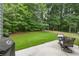 Backyard featuring a stone patio with patio furniture and a green lawn at 1803 Gold Finch Way, Lawrenceville, GA 30043