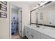 Bright bathroom featuring a single sink vanity, decorative mirror, floral-patterned shower curtain and natural light at 1803 Gold Finch Way, Lawrenceville, GA 30043