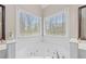 Corner bathtub with tile surround and two windows at 1803 Gold Finch Way, Lawrenceville, GA 30043