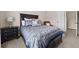Bedroom features a decorative bed, lamp, neutral walls, carpeted flooring, and a view to the hallway at 1803 Gold Finch Way, Lawrenceville, GA 30043