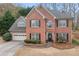 Classic two-story brick home featuring an attached garage and a welcoming front entrance at 1803 Gold Finch Way, Lawrenceville, GA 30043