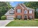Charming two-story brick home featuring a manicured lawn and attached two-car garage at 1803 Gold Finch Way, Lawrenceville, GA 30043