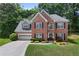 Traditional two-story brick home with manicured lawn and mature trees at 1803 Gold Finch Way, Lawrenceville, GA 30043