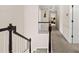 Carpeted upstairs hallway features white wainscotting and dark wood handrails, with a view to several rooms at 1803 Gold Finch Way, Lawrenceville, GA 30043