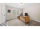 A comfortable home office features a large window, modern desk, neutral walls and carpeted flooring at 1803 Gold Finch Way, Lawrenceville, GA 30043