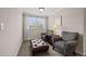 Cozy sitting area with two chairs, ottoman, and window with natural light at 1803 Gold Finch Way, Lawrenceville, GA 30043