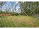 Backyard view showing a chain-link fence enclosing a grassy yard with trees in the background at 4329 Cedar Valley Ln, Conley, GA 30288