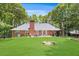 Large backyard with a well-kept lawn, brick patio, and brick house at 7350 S Mitchell Ct, Villa Rica, GA 30180