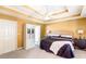 Bedroom with a tray ceiling, ceiling fan, and mustard-colored walls with a closet at 7350 S Mitchell Ct, Villa Rica, GA 30180
