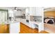 Updated kitchen with granite counters, white cabinets, and stainless appliances offers a built-in workspace at 7350 S Mitchell Ct, Villa Rica, GA 30180