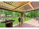 Back patio has outdoor kitchen area with stainless steel grill overlooking a large green yard at 7350 S Mitchell Ct, Villa Rica, GA 30180