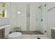 Bathroom with glass enclosed shower, white tile, and a dark grey vanity, complemented by bright natural light at 1131 Hershey Dr, Marietta, GA 30062
