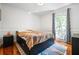 Cozy bedroom with hardwood floors, a large window, and a comfortable bed with drawer storage at 1131 Hershey Dr, Marietta, GA 30062