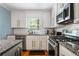 This kitchen features white cabinets, granite countertops, stainless steel appliances, and a subway tile backsplash at 1131 Hershey Dr, Marietta, GA 30062