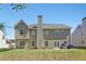 Backyard view of two-story home with a patio, lawn and neighboring residences at 2277 Shady Maple Trl, Loganville, GA 30052