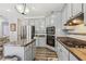 Elegant kitchen boasts gray cabinets, stainless steel appliances, and granite countertops at 2277 Shady Maple Trl, Loganville, GA 30052