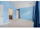 Spacious bedroom with neutral carpet and blue walls with an en-suite bathroom at 2620 Paddock Point Pl, Dacula, GA 30019