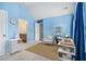 Bright bedroom featuring soft blue walls, neutral carpeting, desk, shelf and chair at 2620 Paddock Point Pl, Dacula, GA 30019
