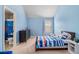 Cheerful bedroom with blue walls, nautical-themed bedding, and an adjacent bathroom at 2620 Paddock Point Pl, Dacula, GA 30019