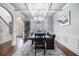 Elegant dining room with wainscoting, coffered ceiling, and chandelier lighting at 2620 Paddock Point Pl, Dacula, GA 30019