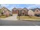 Well-maintained brick home with blossoming tree, a paved driveway, and a lush front lawn at 2620 Paddock Point Pl, Dacula, GA 30019