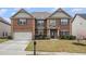 Charming two-story brick home with a well-manicured lawn, mailbox, and attached two-car garage at 2620 Paddock Point Pl, Dacula, GA 30019