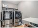 Laundry room featuring updated washer and dryer with storage and folding table at 2620 Paddock Point Pl, Dacula, GA 30019