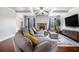 Inviting living room featuring a stone fireplace, coffered ceiling, and a plush gray sectional at 2620 Paddock Point Pl, Dacula, GA 30019