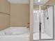 Bathroom highlighting a shower and soaking tub with tile floors and neutral colored walls at 4125 Madison Bridge Dr, Suwanee, GA 30024