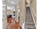 Hallway with hardwood floors leads to a staircase and open living space with a fireplace and comfortable seating at 4125 Madison Bridge Dr, Suwanee, GA 30024