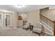 Cozy living room featuring carpet floors, chair seating area, and a staircase at 4125 Madison Bridge Dr, Suwanee, GA 30024