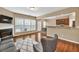 Open living room with a fireplace, hardwood floors, and a view into the adjacent kitchen area at 4125 Madison Bridge Dr, Suwanee, GA 30024
