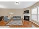 Inviting living room with a fireplace, hardwood floors, and abundant natural light from large windows at 4125 Madison Bridge Dr, Suwanee, GA 30024