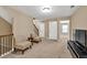 Upstairs loft with neutral carpet, two accent chairs, a TV, and access to bedrooms at 4125 Madison Bridge Dr, Suwanee, GA 30024