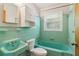 Vintage turquoise bathroom with tiled walls, bathtub, and sink at 454 Jo Ann Se Dr, Marietta, GA 30067